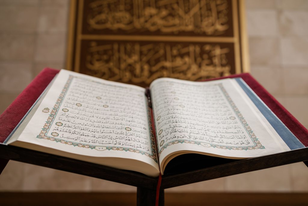 Open Quran on a wooden stand  
